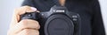 Tbilisi, Georgia - July 26, 2022: Person holding modern Canon EOS R5 camera closeup in hand