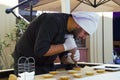 Confectioner chef cooking dessert scene, chef decorates cake and working in the street of Tbilisi on the city festival