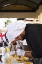 Confectioner chef cooking dessert scene, chef decorates cake and working in the street of Tbilisi on the city festival