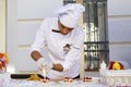 Confectioner chef cooking dessert scene, chef decorates cake and working in the street of Tbilisi on the city festival