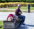 Tired elderly tourists rest on a bench in Rike Park in old part of Tbilisi city in Georgia