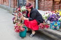 TBILISI, GEORGIA - October 21, 2019: A woman with flowers sits on a bench on a city street