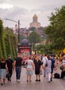 Tbilisi, Georgia - 08 29 2023: Tourists walking beside tables and umbrellas of patio cafes in old two-story buildings of