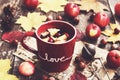 Tea with apple and cranberry and autumn leaves