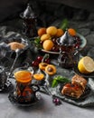 Tea armud in Turkish style with lemon. served on a silk tablecloth with baklava and fruit-cherries and apricots