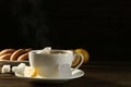 Tea bag in ceramic cup of hot water and lemon on dark wooden table. Space for text Royalty Free Stock Photo