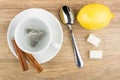 Tea bag in cup, cinnamon sicks on saucer, lemon, sugar Royalty Free Stock Photo