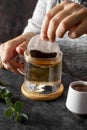 Tea bag in glass cup of tea. Female hand with bag of black tea. Hot drink, lifestyle photo Royalty Free Stock Photo