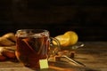 Tea bag in glass cup of hot water on wooden table against dark background, space for text Royalty Free Stock Photo