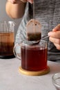 Tea bag in glass cup of tea. Female hand with bag of black tea. Hot drink, lifestyle photo Royalty Free Stock Photo