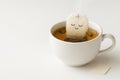 Tea bag in meditation pose in a cup with a drink. Space for text. Royalty Free Stock Photo