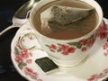 Tea bag steeping in a floral teacup Royalty Free Stock Photo