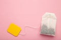 Tea bag with yellow blank label on pink background. Copy space for text Royalty Free Stock Photo