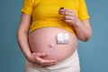 Tea bags in the hands of a pregnant woman on a blue background Royalty Free Stock Photo