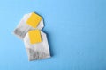 Tea bags with tabs on light blue wooden table, top view. Space for text Royalty Free Stock Photo