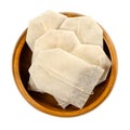 Tea bags, made of filter paper, with tea in a wooden bowl