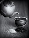 Tea being poured into a ceramic cup from a teapot.