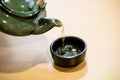 Tea is being poured out of the rake into a teacup. Asia traditional health drinking.