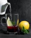 Tea with black currant berries, fresh mint and lemon wedges. Royalty Free Stock Photo
