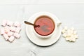 Tea break concept. Mug with black tea and sweets. Mug filled with black brewed tea, spoon and heap of marshmallow and Royalty Free Stock Photo