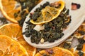 Tea buds with dried oranges. Green tea with dried citruses in a wooden spoon Royalty Free Stock Photo
