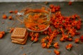 Tea with calendula flowers and biscuits. Transparent glass cup and saucer Royalty Free Stock Photo