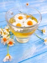 Tea with camomile on wooden background summer