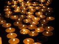 Tea candles in a row burning on black background Royalty Free Stock Photo