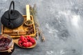 Tea in a cast iron teapot and a spoonful of raspberries