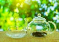 Tea ceremony. An empty glass teapot with tea leaves stands on a wooden table against the background of a beautiful nature with Royalty Free Stock Photo
