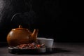 Tea ceremony. The process of brewing tea. Teapot and cups with freshly brewed vitamin drink from rosehip, dark mood. Space for
