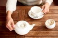 Tea ceremony with table set for tea with white kettle, sugar bowl and cup on wooden table. Tea traditions Royalty Free Stock Photo