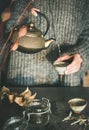 Woman pouring tea from golden teapot into cup Royalty Free Stock Photo