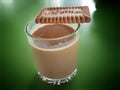 Tea chai and biscuit on green background table In India , Indian masala chai tea or black tea made with various spices and ingredi