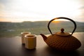 Tea concept. Japanese tea ceremony culture east beverage. Teapot and cups on table with bamboo leaves on sunset