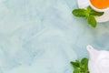 Tea concept. Teapot and cup with green herbal tea decorated mint leaves on wooden background. Royalty Free Stock Photo