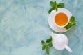 Tea concept. Teapot and cup with green herbal tea decorated mint leaves Royalty Free Stock Photo