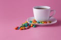 Tea cup with colored sweet dragees on saucer