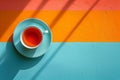 Tea cup on a colorful surface with bright light and shadows