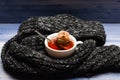 Tea cup and dipped bag of tea wrapped with knitted scarf. Autumn drink concept. Mug filled with boiling water, teabag