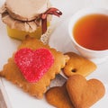 Tea cup with heart shaped biscuits. Sugar red biscuits. A square, equal sides. Instaphoto with filters