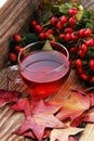 Tea. cup of herbal Dog rose tea with bunch branch Rosehips, type