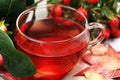 Tea. cup of herbal Dog rose tea with bunch branch Rosehips, type