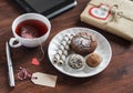 Tea cup with a homemade tea bag, sweets - cake, cookies and homemade candy, homemade Valentine's day gift in kraft paper and table Royalty Free Stock Photo