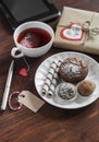 Tea cup with a homemade tea bag, sweets - cake, cookies and homemade candy, homemade Valentine's day gift in kraft paper