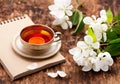 Tea cup, notebook and white spring flowers Royalty Free Stock Photo