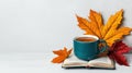 Tea cup on open book surrounded by autumn leaves white isolate background Royalty Free Stock Photo