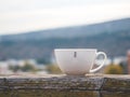 Tea cup on the outdoor wooden terrace and autumn city background Royalty Free Stock Photo