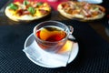 Tea cup on plate with pizza Royalty Free Stock Photo