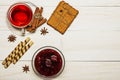 Tea in a cup with raspberry jam, cookies, croissants, cinnamon, anise, caramel sticks. On a white wooden table. Christmas composit Royalty Free Stock Photo